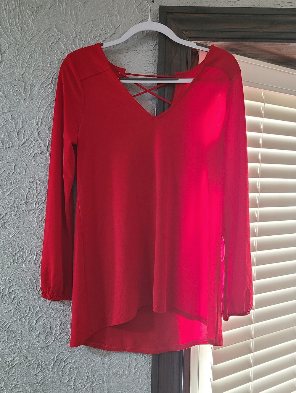 Red Express long sleeve v-neck blouse featuring a criss-cross strap design back